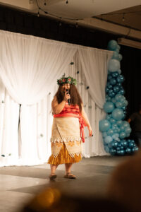 A Moana performer talks on stage.