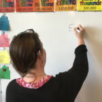 Rhonda writes with a marker on a dry erase board in her classroom..