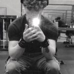 A black and white selfie of Blake taken in a gym.