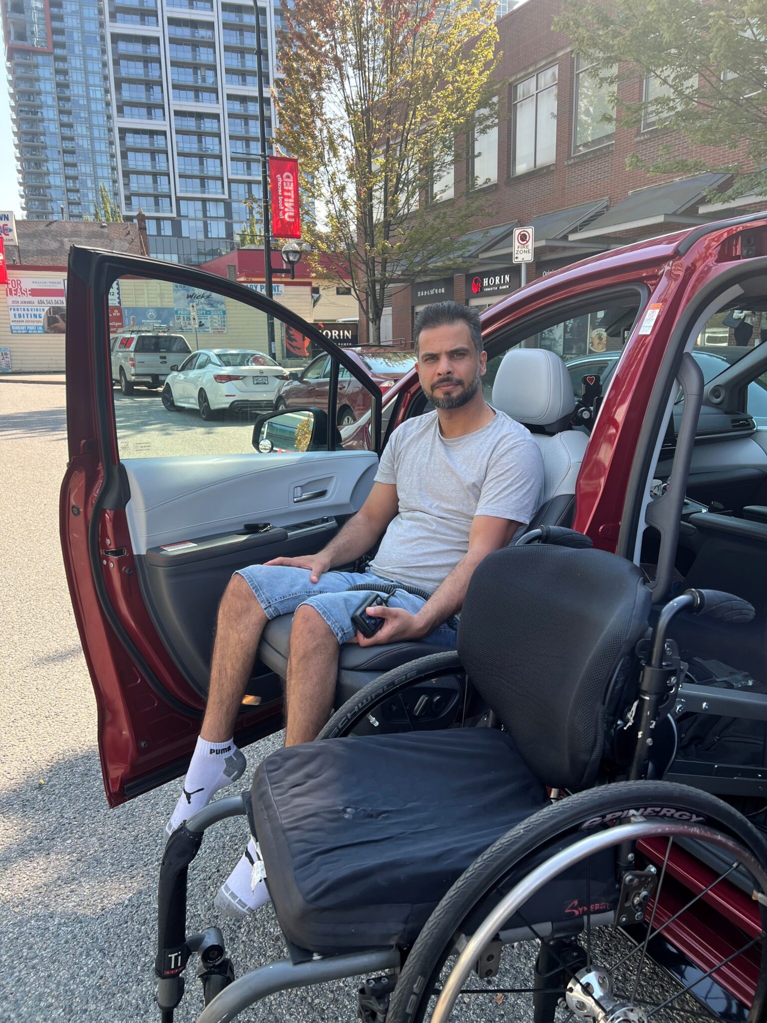 Ahmed using his transfer seat and wheelchair lift to get in his van.