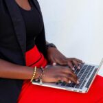 A woman types on a laptop.