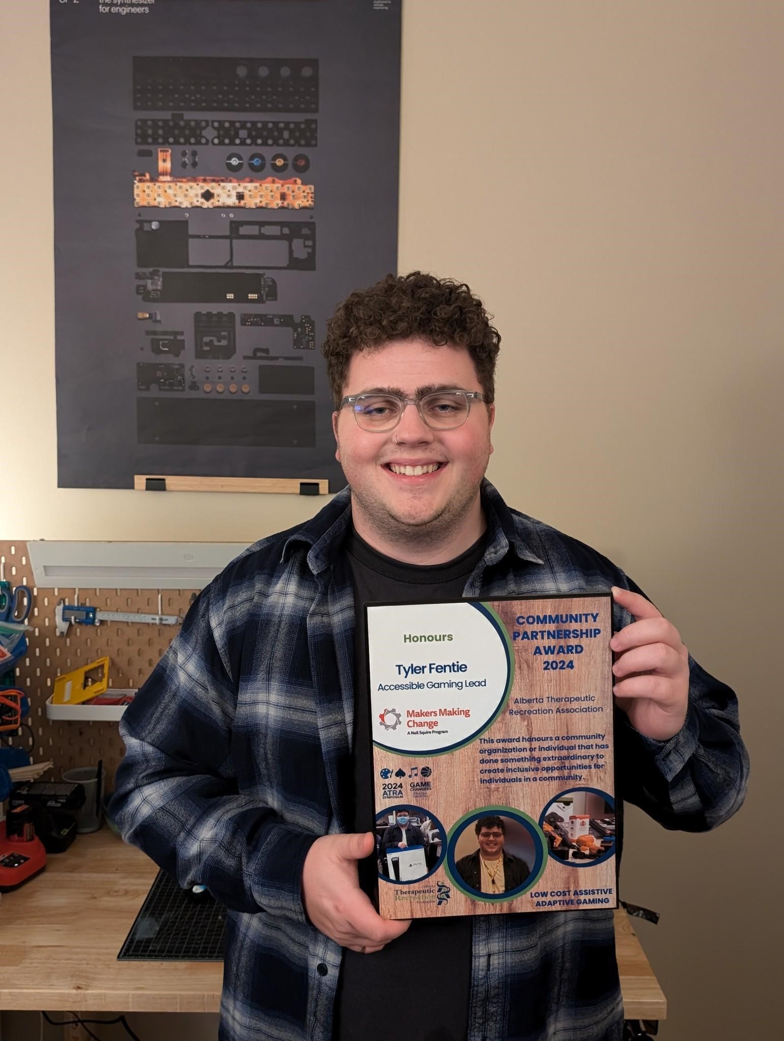 Tyler holding up his Community Partnership Award.