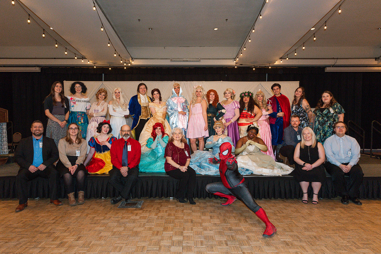 Neil Squire Prairie Region staff pose in a group picture with all the prince, princess, and superhero performers.