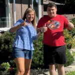Office manager Lori and Creative Employment Options participant Austin give a thumbs up.