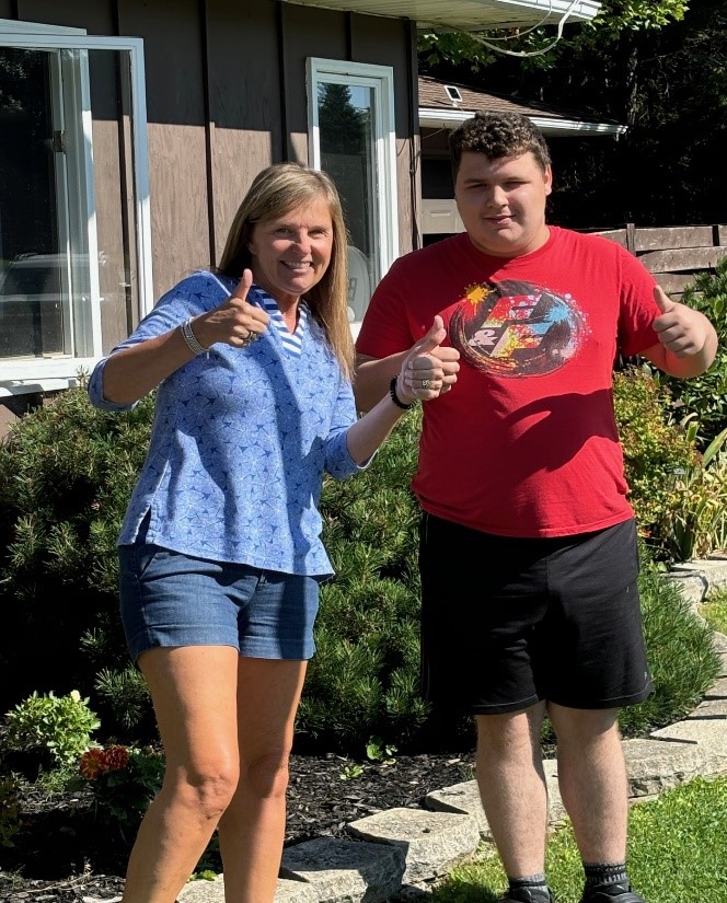 Office manager Lori and Creative Employment Options participant Austin give a thumbs up.
