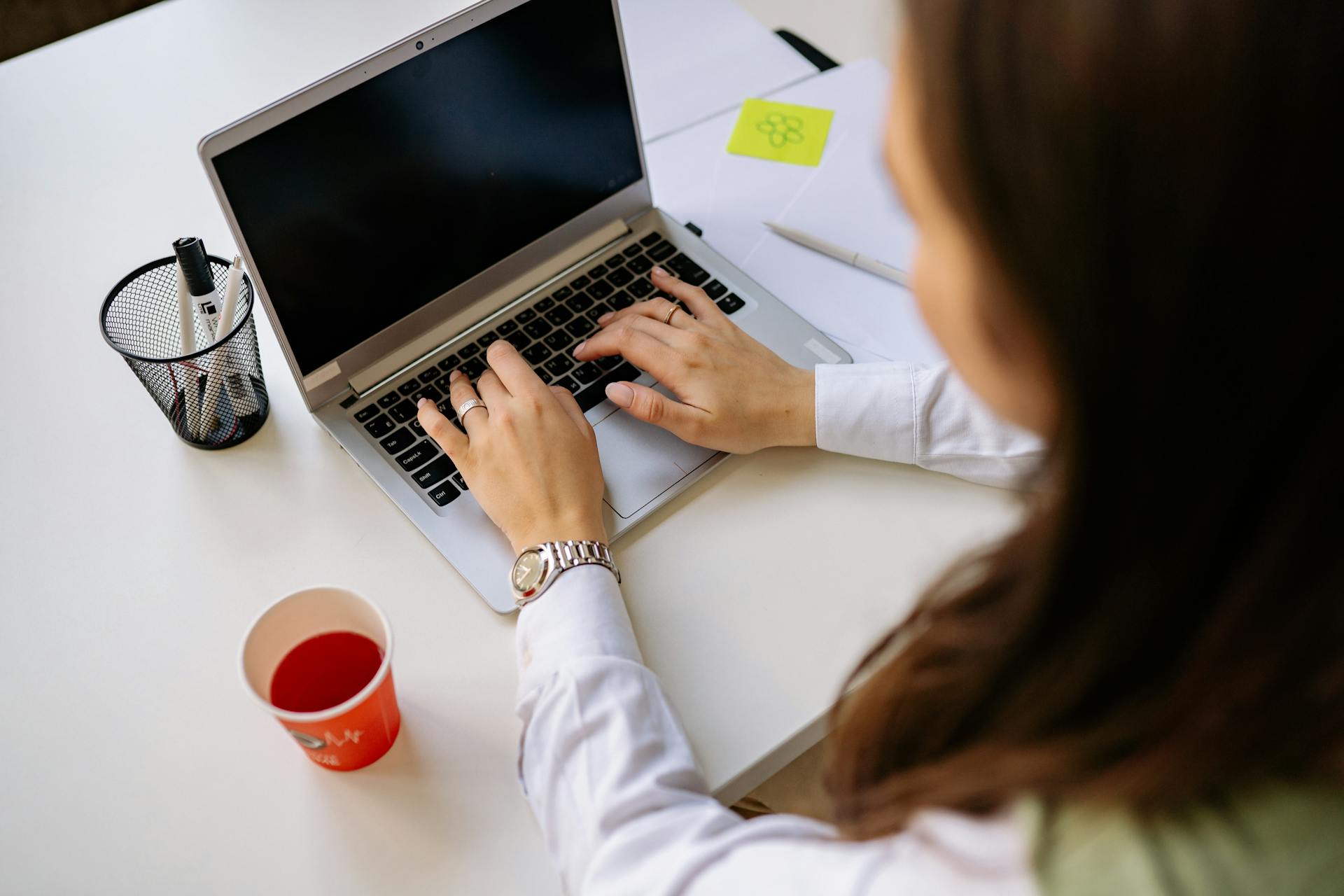 A woman types on a laptop.
