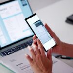 A person uses a phone to scan a document.