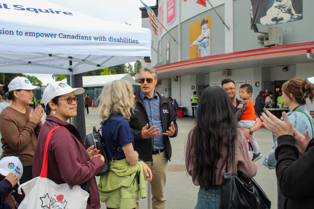 Neil Squire staff chat outside the booth.