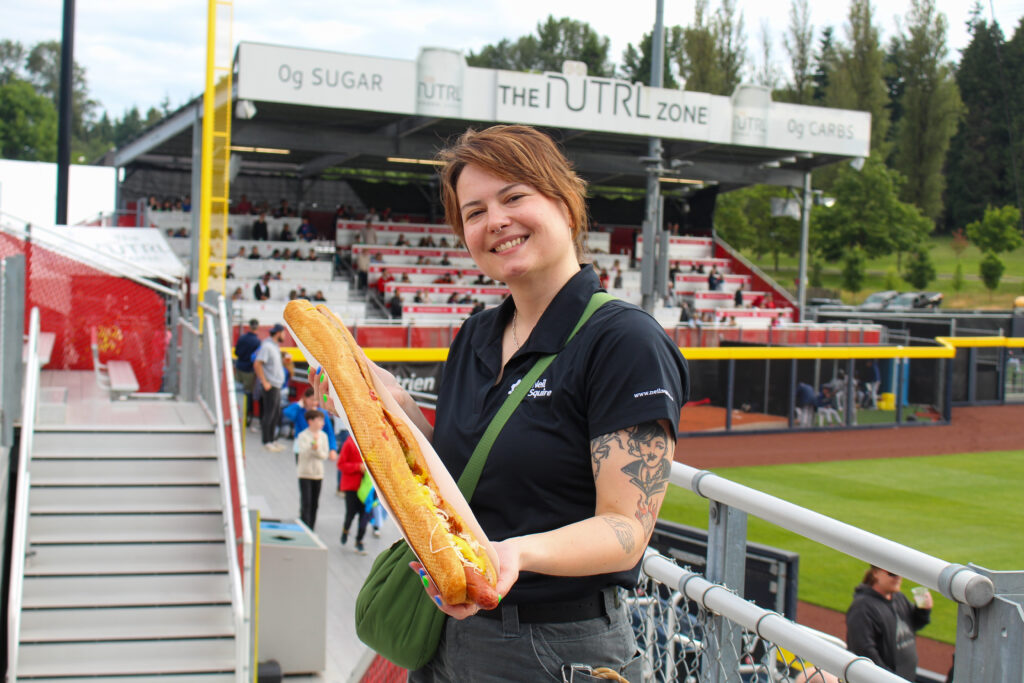 Kris holds a yard-long hot dog.