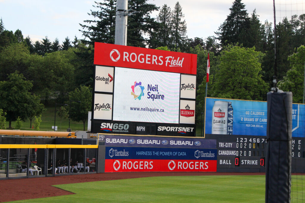 The Neil Squire logo appears on the screen in the ball park.