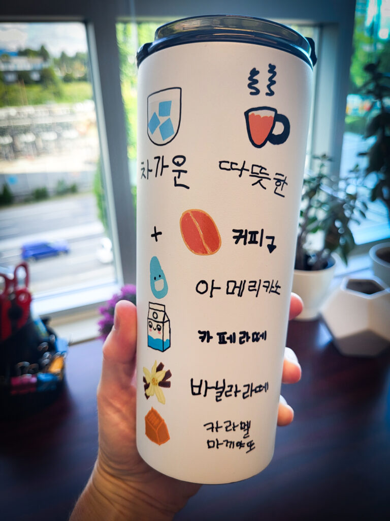 A coffee mug from the Purme Foundation delegation with Korean writing that can be used by people with verbal disabilities to order coffee at a coffee shop.