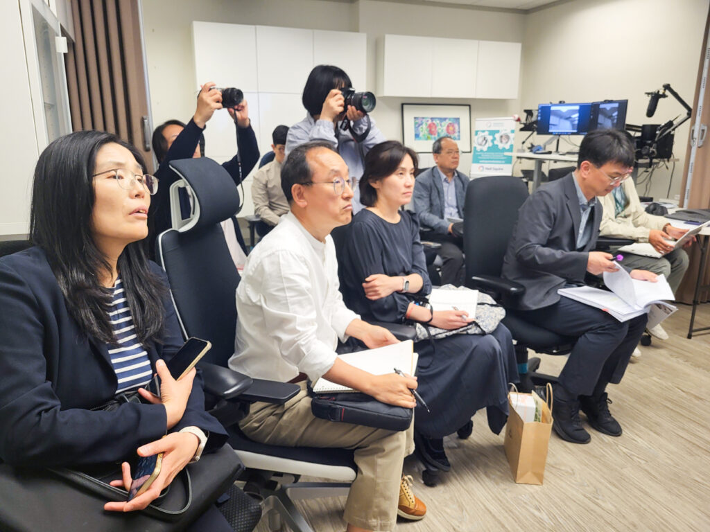 The delegation watches intently in the Hearing Solutions lab.