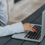 A woman types on a laptop.