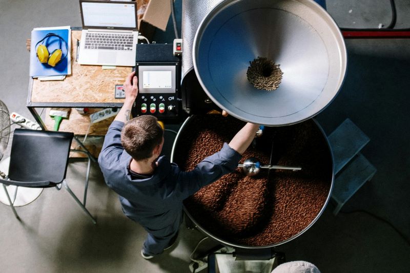 A man working with a coffee roasting machine