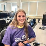 Clubs That Care youth leader Skye wearing a Worlds UNBound shirt and sitting in front of a soldering iron.