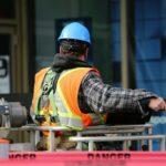A man wearing a high viz vest and a hard hat at a construction site.