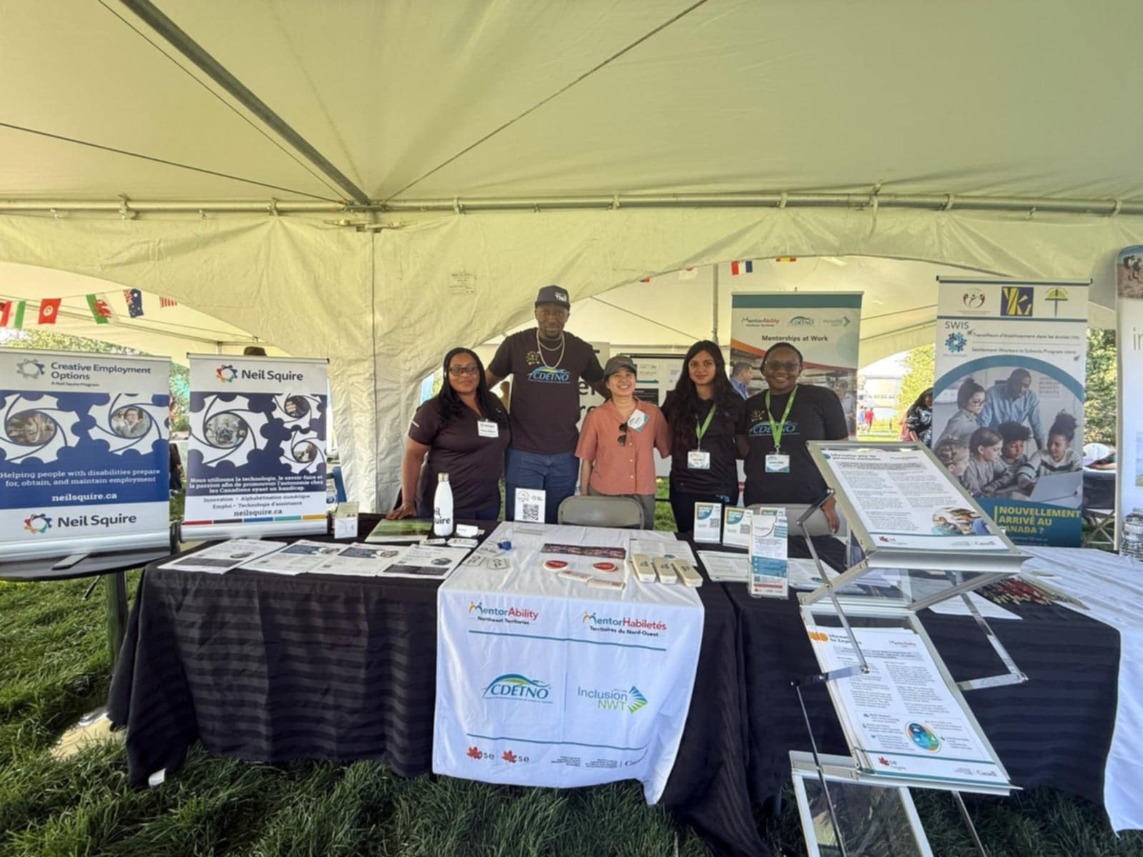 Mercy with the CDETNO team at the shared booth.