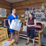 Cassandra holding a gift bag from Mindy.