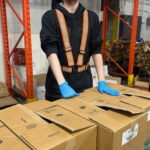 Gregory, at work, handling boxes.