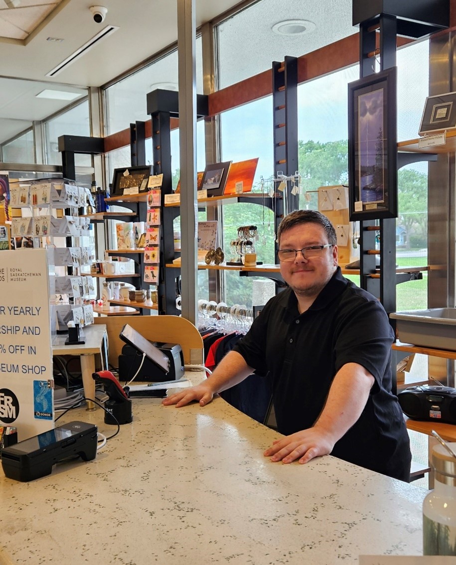 Creative Employment Options participant Tyler at work at the museum gift shop.