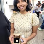 Khatidja holding a golden Neil Squire pin.