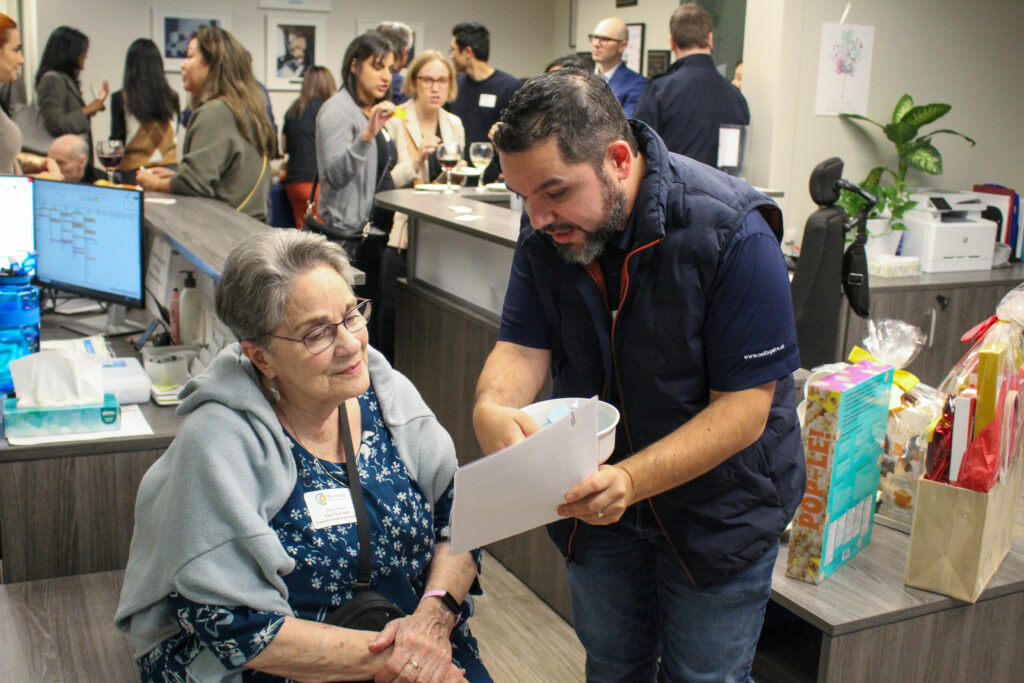 Enrique discusses a program with an attendee.