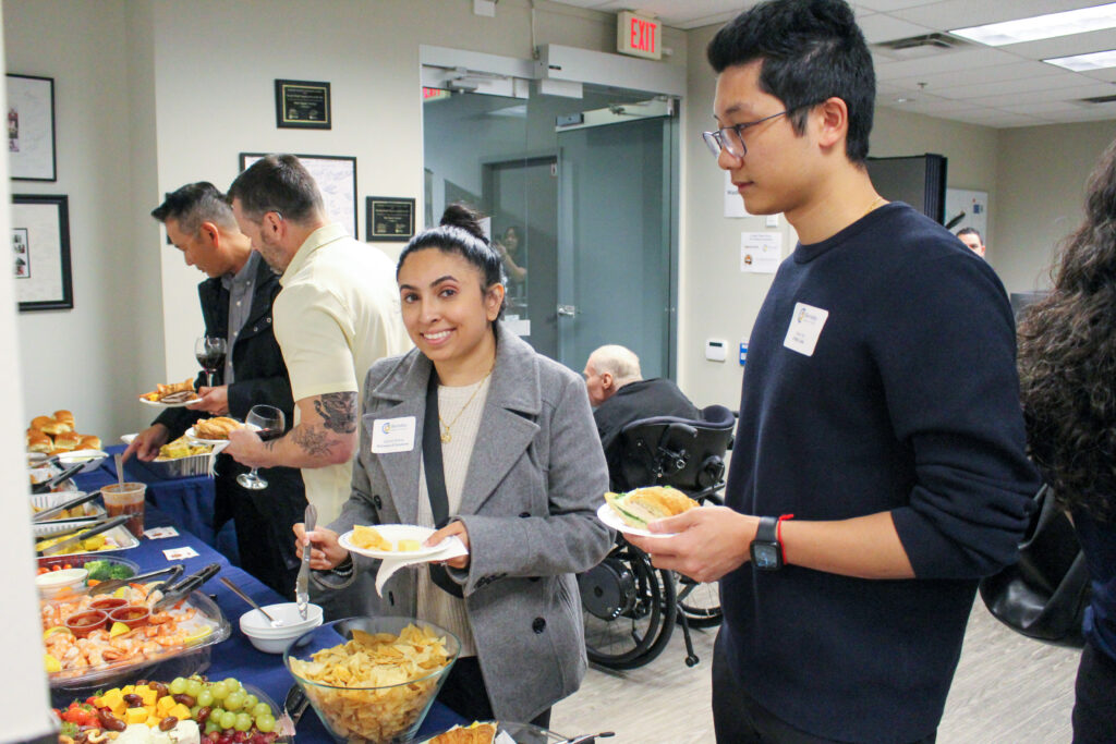 A woman smiles as she gets a plate of food.
