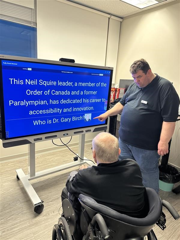 Gordon showing Gary a Jeopardy question at one of the event's stations.