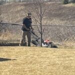 Kristian mowing a lawn at his new job.