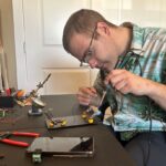 An image from the CTV feature showing Nicolas doing some soldering while working on a device.