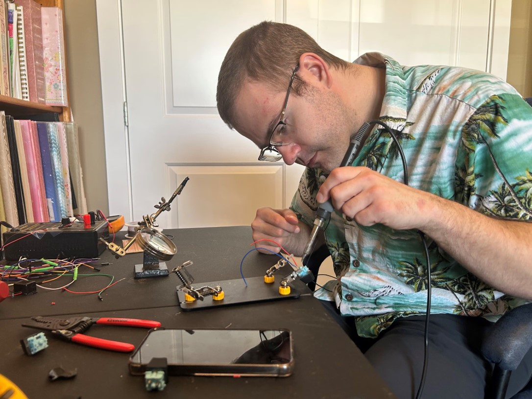 An image from the CTV feature showing Nicolas doing some soldering while working on a device.
