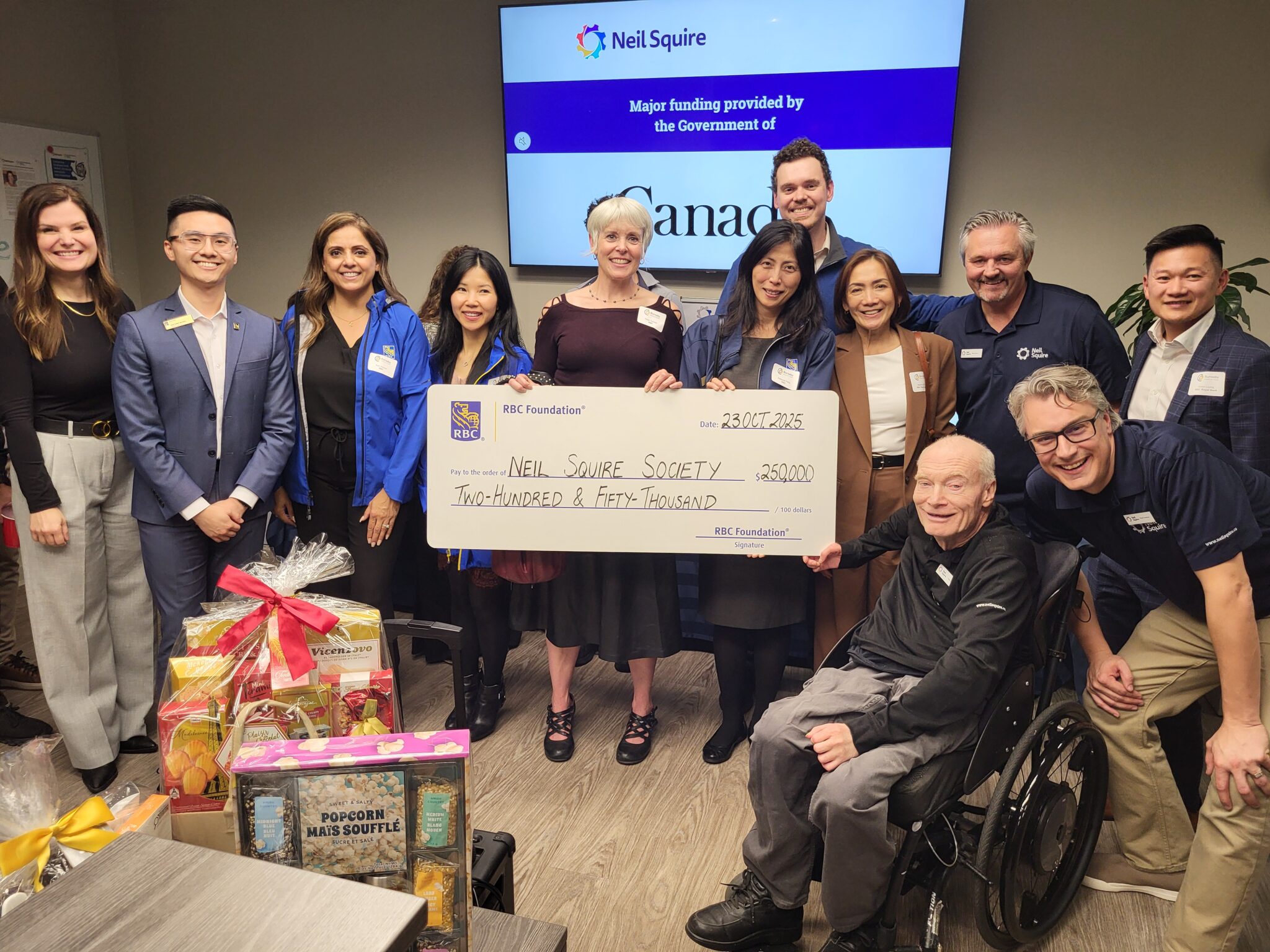 RBC staff members, Burnaby Board of Trade president and CEO Angie Whitfield, Neil Squire staff Gary Birch, Nate Toevs, and Chad Leaman hold the $250,000 cheque.