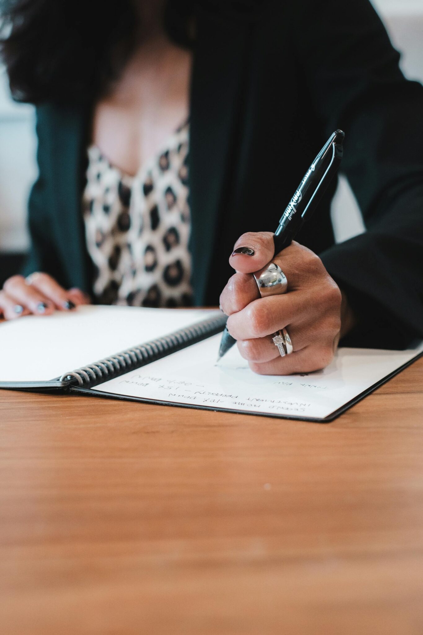 A woman writes in a notebook.