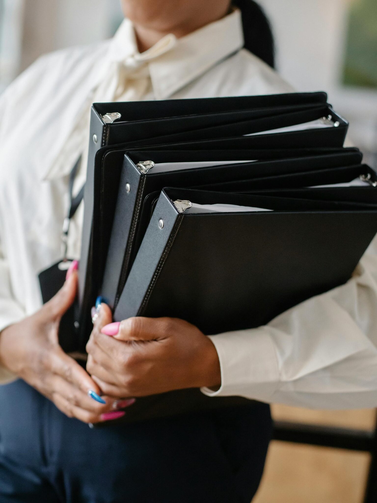 A woman carries binders.