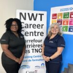 Mercy and Nikki in front of a sign for the NWT Career Centre.