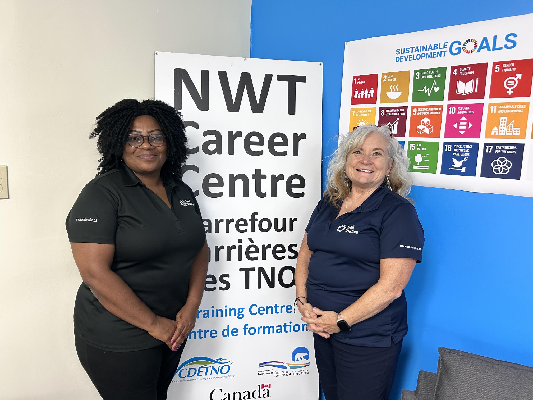 Mercy and Nikki in front of a sign for the NWT Career Centre.