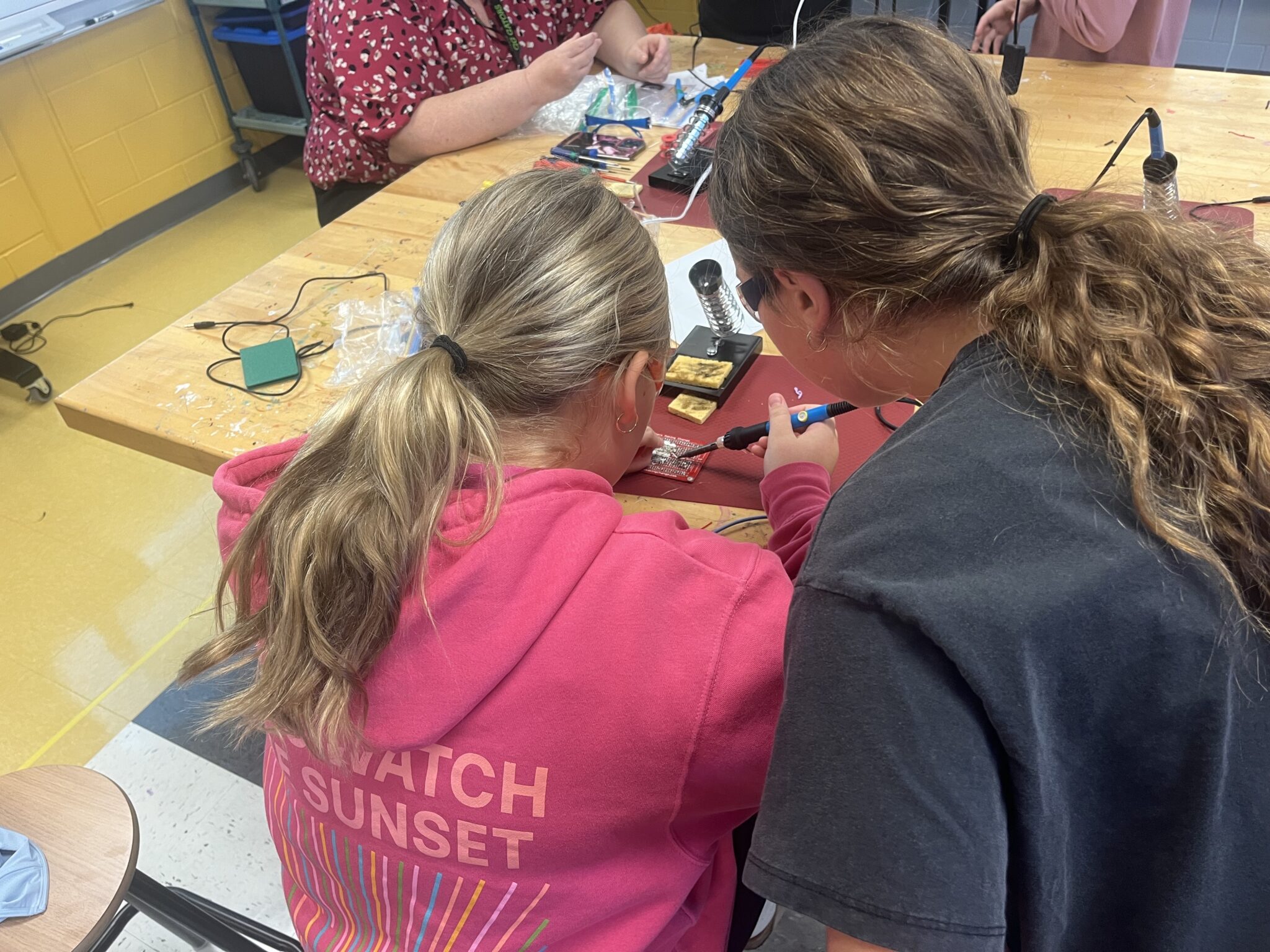 A teacher and a student work on a switch.