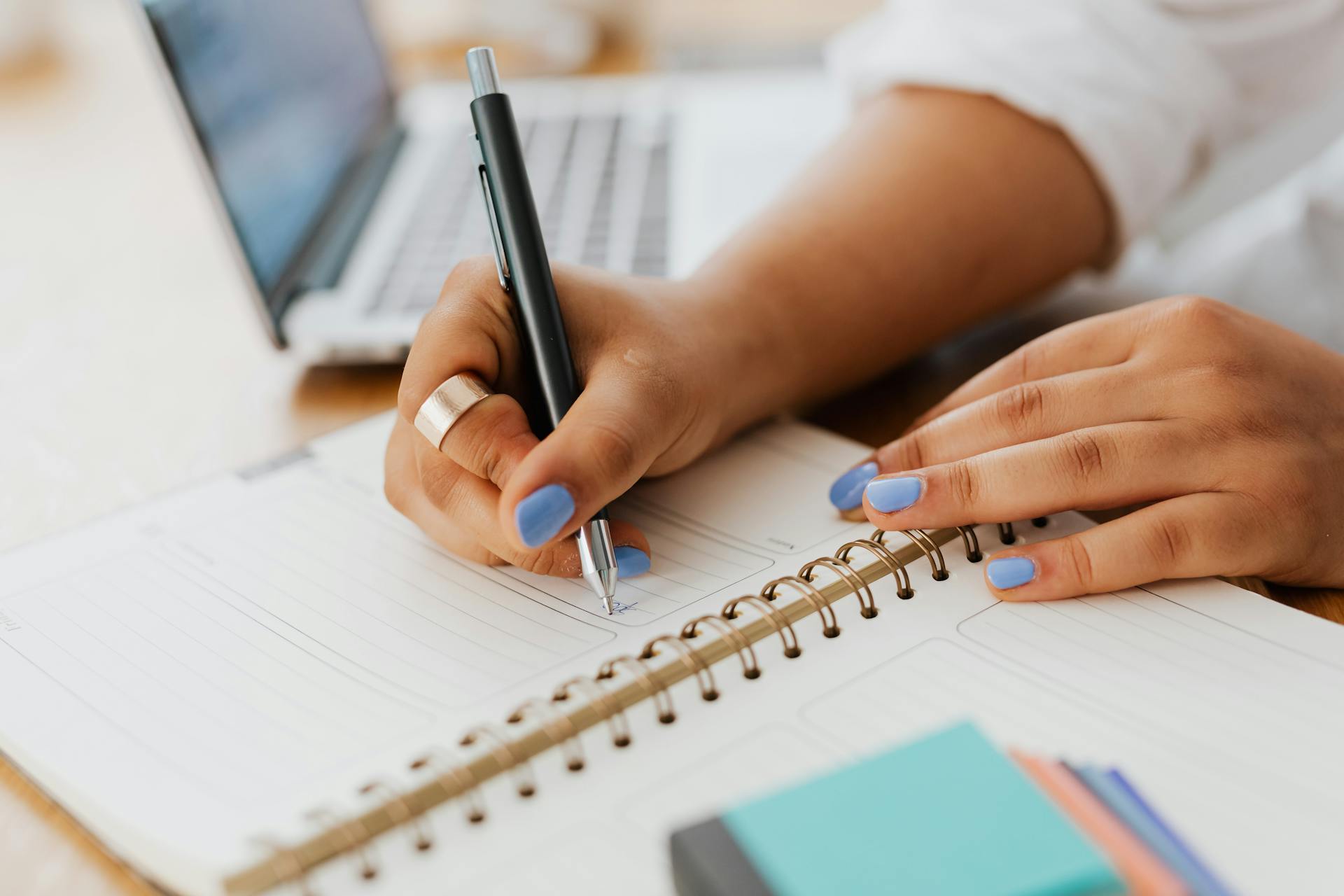 A person writes into a notebook.