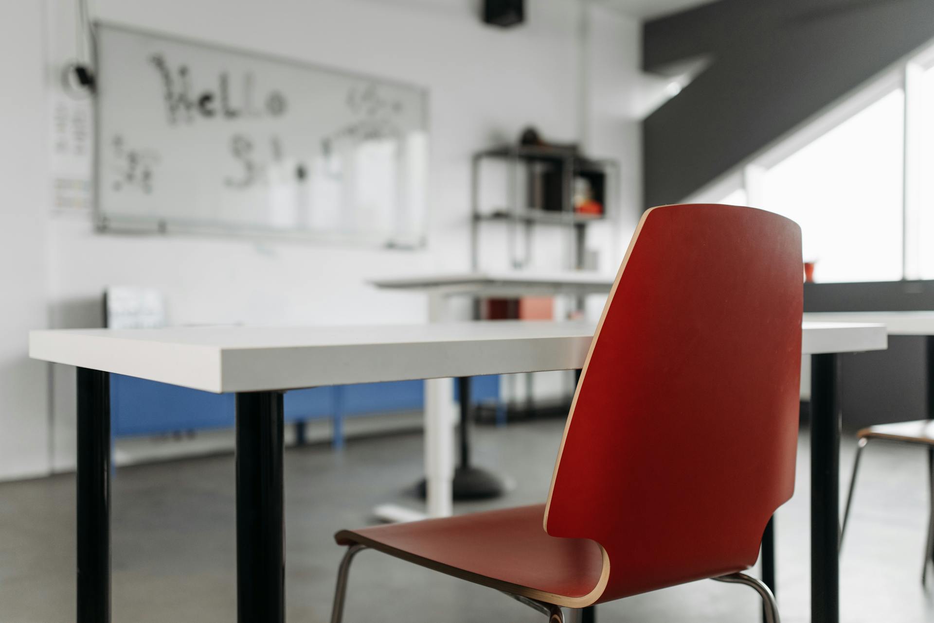 A chair at a desk facing a whiteboard in a classroom.