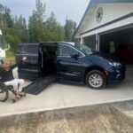 Patricia, in a wheelchair, in front of her wheelchair accessible van with a ramp leading into it.