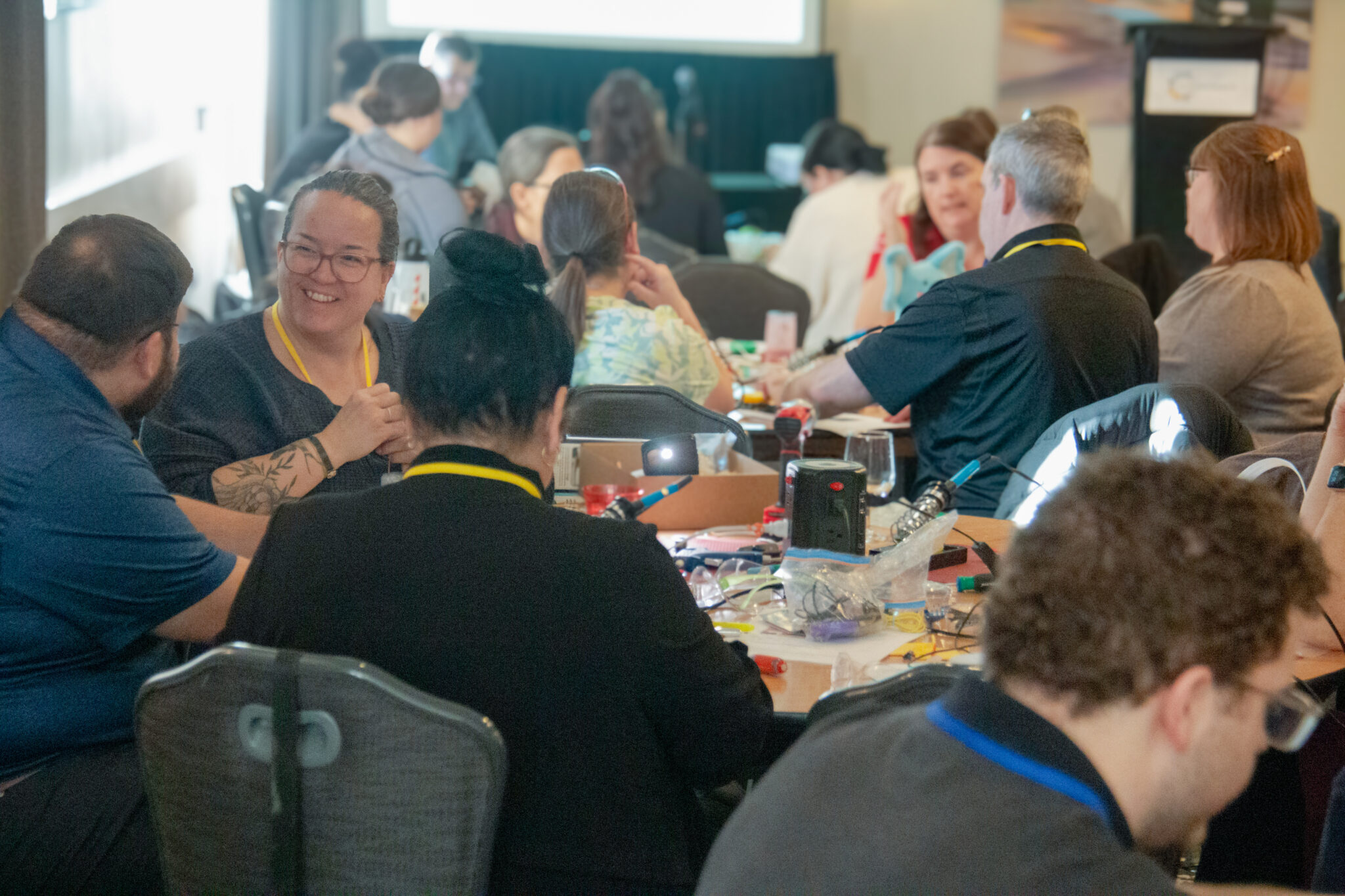 Attendees work on devices together during a build event.