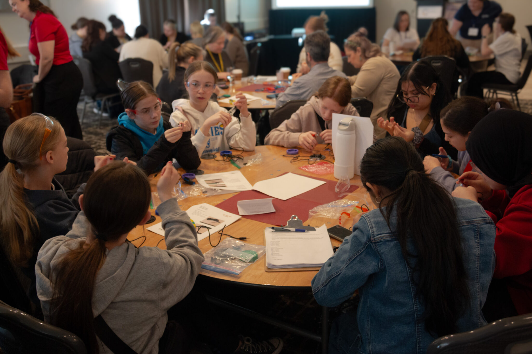 Young student makers work on devices during a build event.