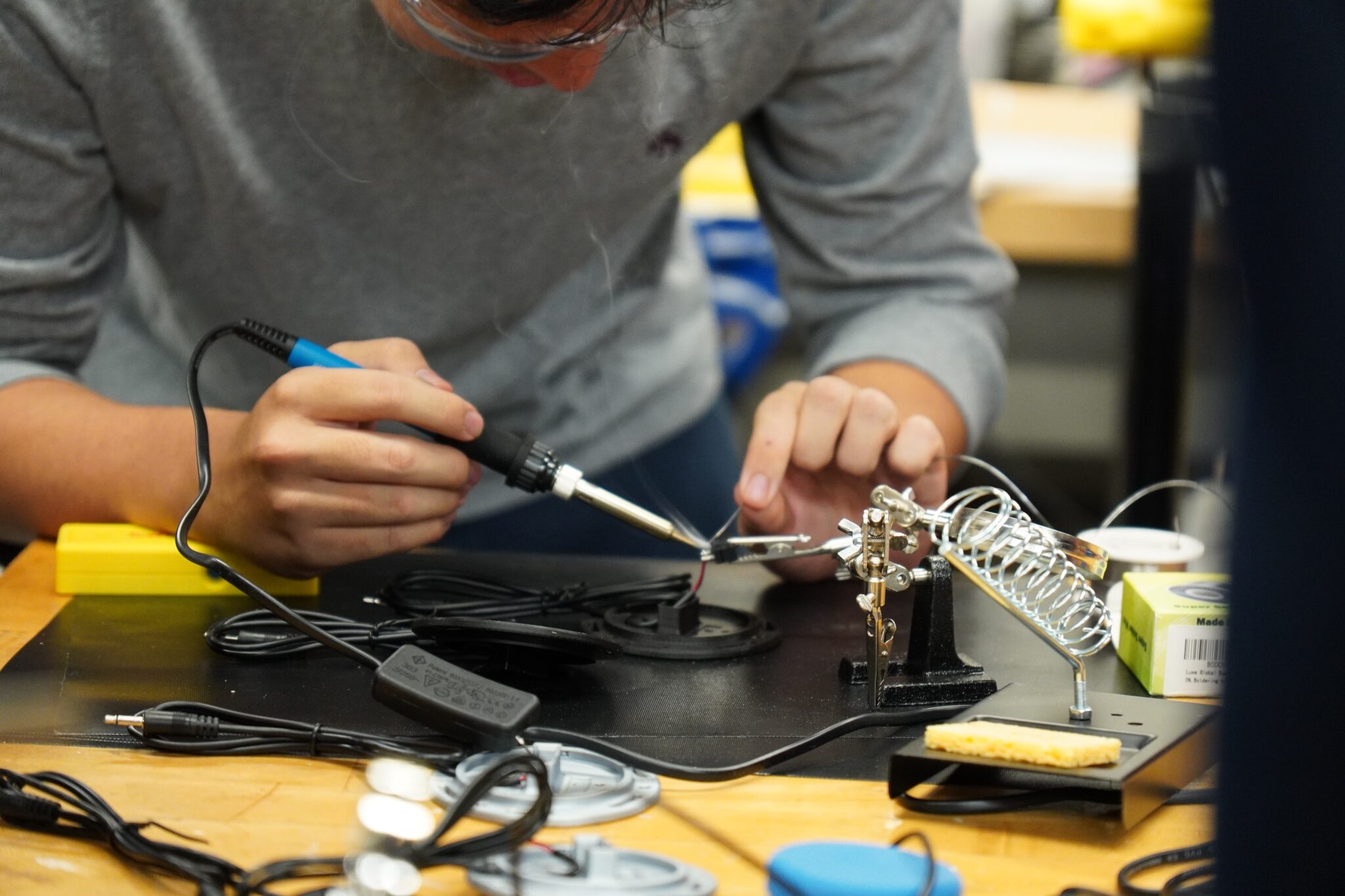 A student does some soldering at a build event.
