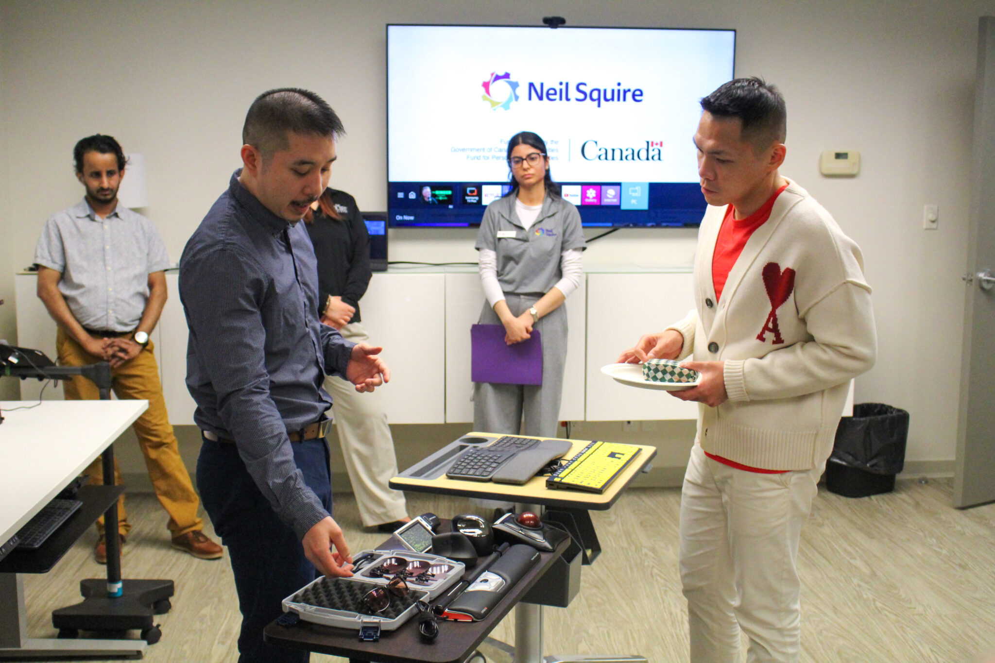 Occupational Therapist Eric Chau gives an assistive technology demonstration MP Wade Chang.