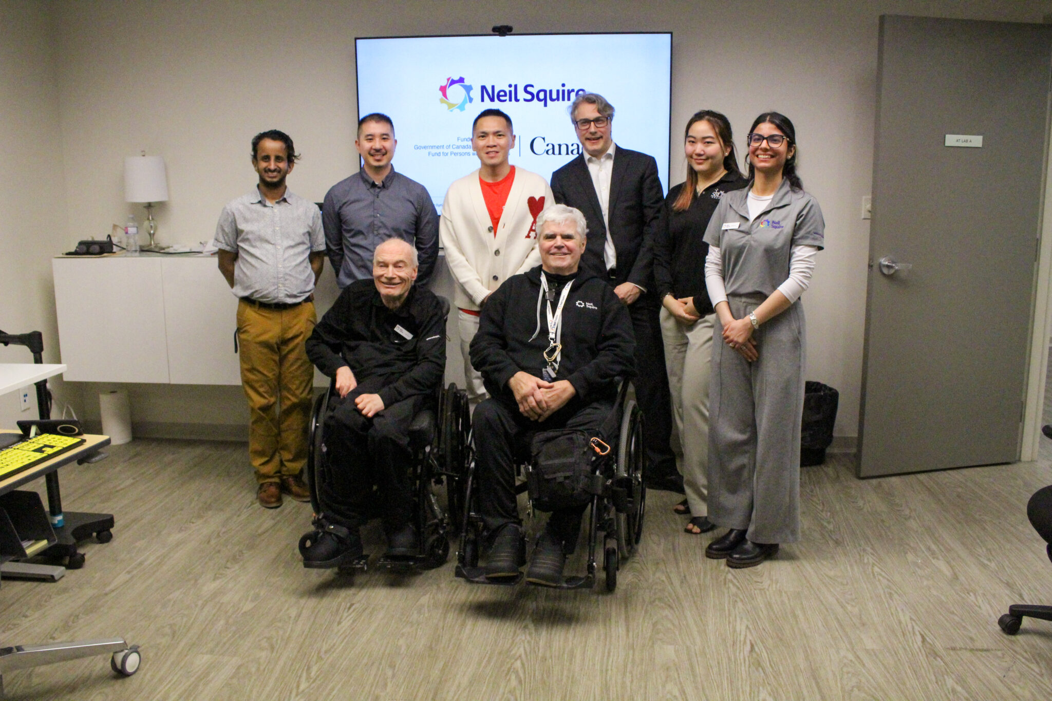 Neil Squire staff, participants, and Wade Chang pose for a photo in the Solutions lab.