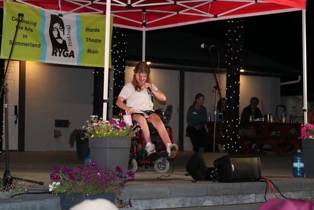 Creative Employment Options participant Rebecca on stage in a wheelchair during the Ryga Arts Festival.