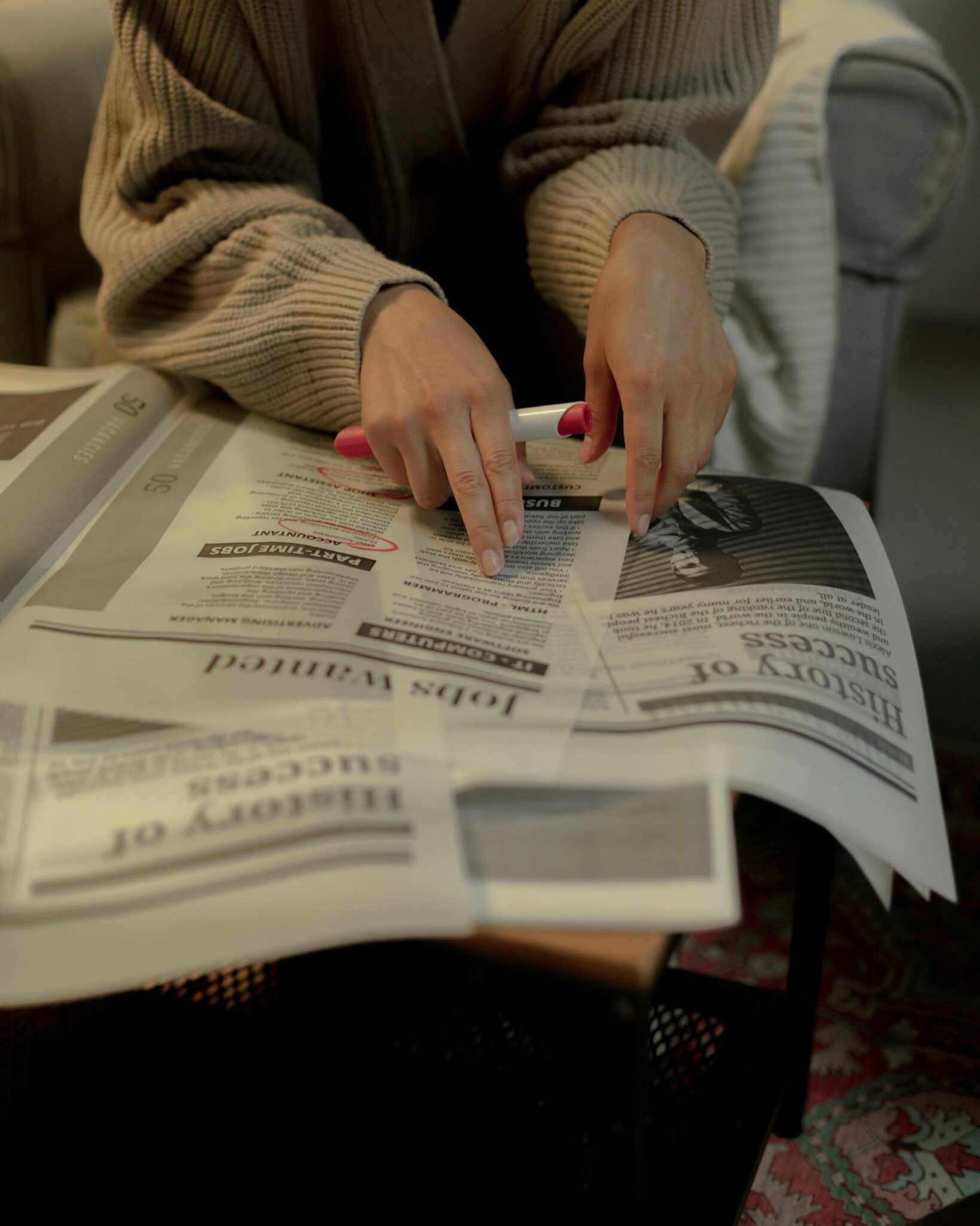 A person looks for work in the classified ads in the newspaper.