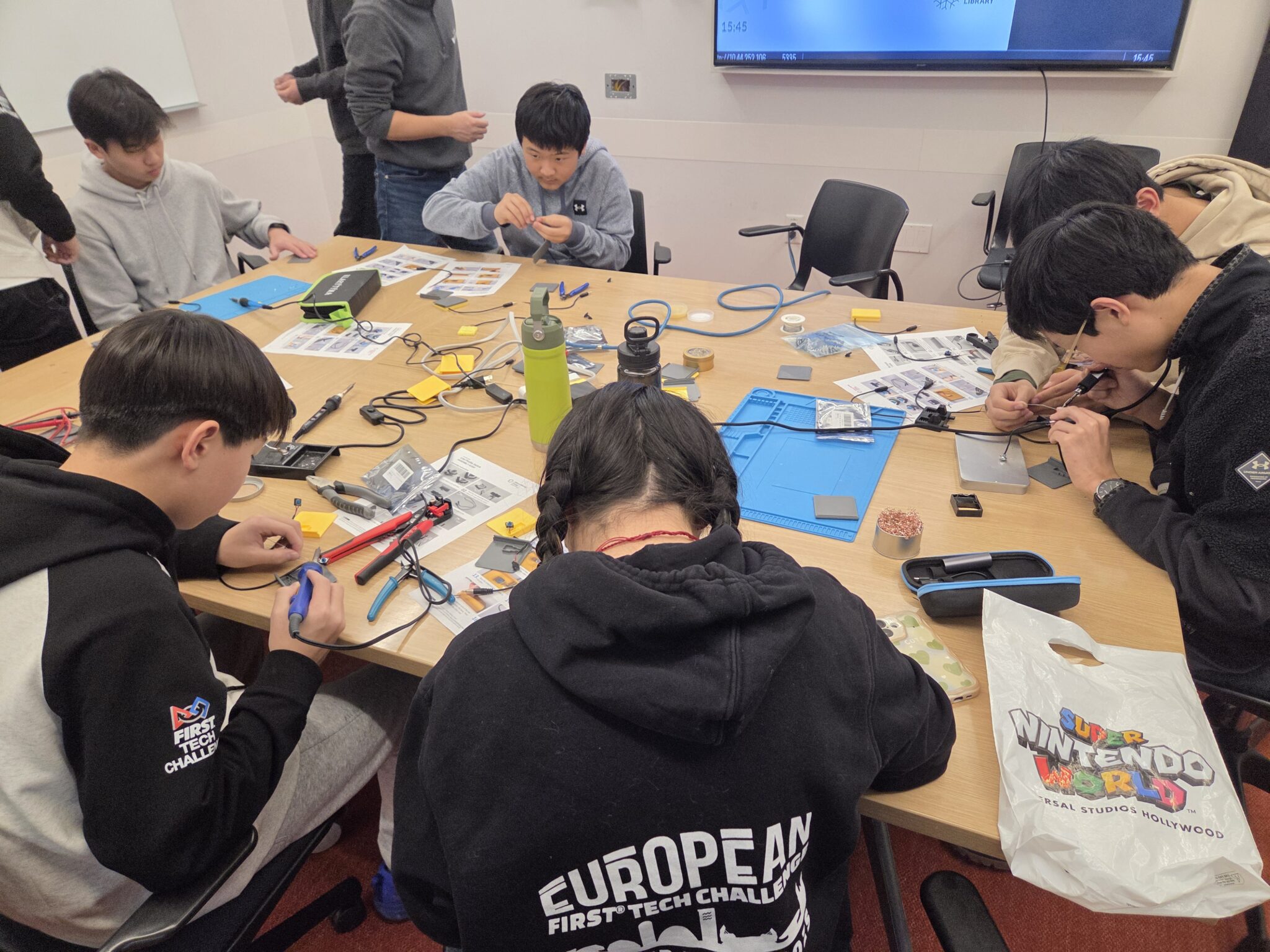 Cybertronic Penguinz club members work together during a build event.