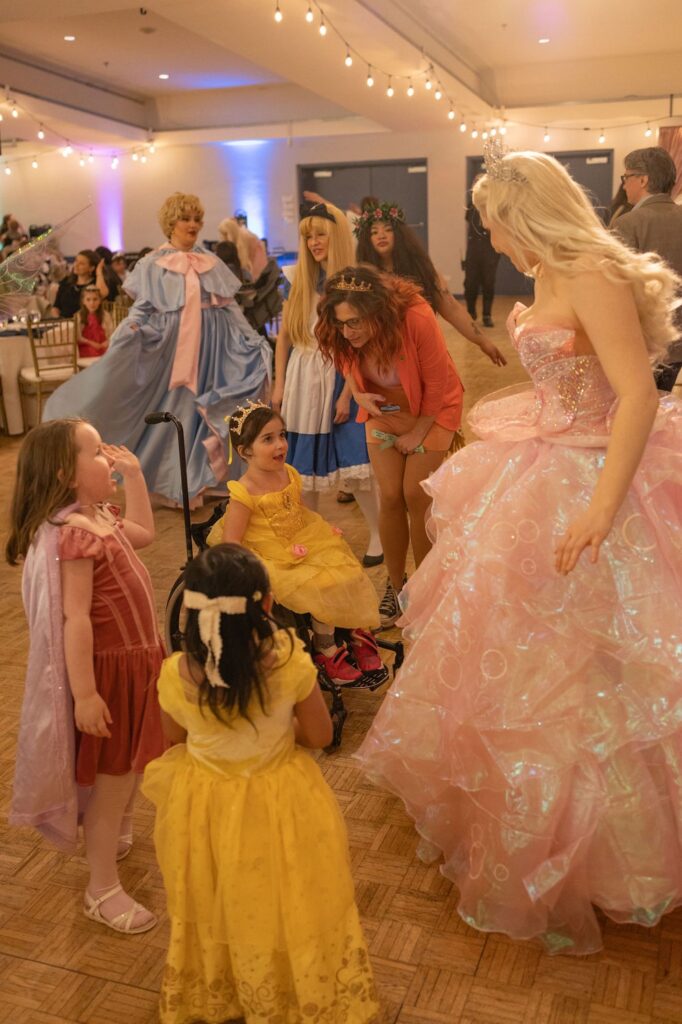 Kids dressed up as princess greet one of the princess performers.