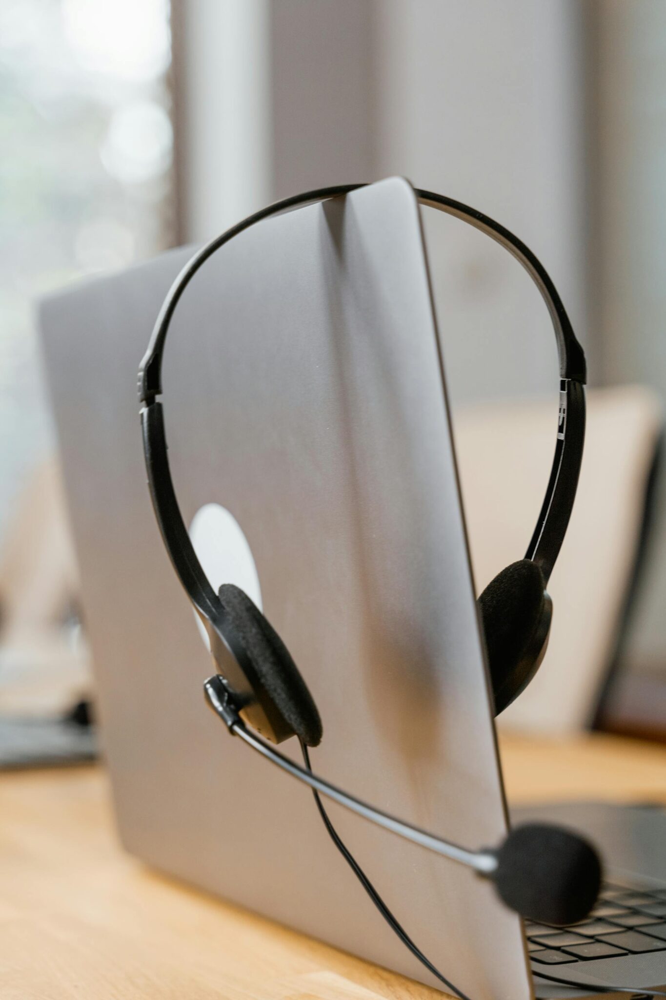 A headset resting on a laptop.